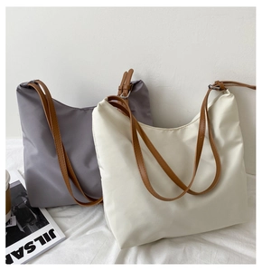 Detail view of stylish tote bags in grey-purple and off-white with adjustable straps