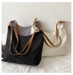 Three minimalist nylon tote bags in black, gray, and cream with brown leather straps