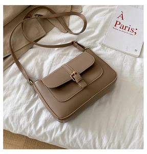 Detailed top view of a brown vintage leather crossbody bag on a minimalist background