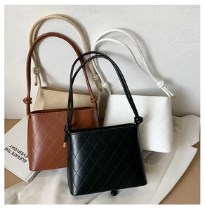 Dettaglio di quattro borse in ecopelle trapuntata nei colori nero, marrone, beige e bianco