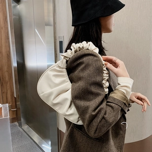 Sac sous le bras froncé beige avec poignée plissée porté sur une tenue d'automne