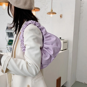 Sac sous le bras plissé violet clair pour femme porté avec un blazer crème élégant