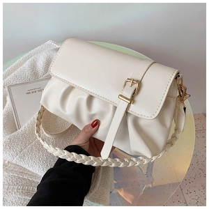 Detail of cream white pleated shoulder bag with woven strap and gold buckle accent
