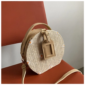 Détail du sac rond en paille tressée avec broderie marguerite et fine bandoulière