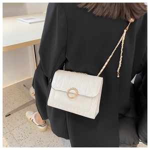 Détail du sac à bandoulière blanc matelassé avec boucle en perles dorées et chaîne