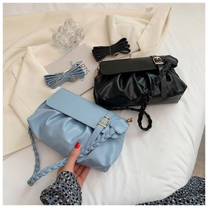 Detail of ruched cloud bags with woven handles and metal buckles in black and light blue