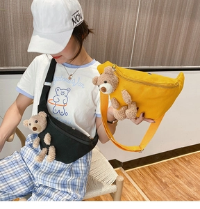 Detail of adjustable straps and cute plush bear on black and yellow canvas chest bags