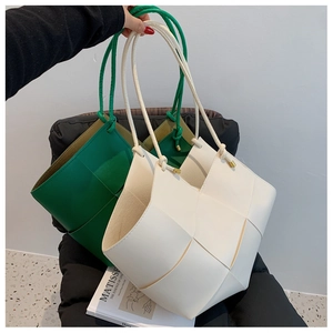 Detail of hand-woven tote bags in green and cream white with wide cross-weave texture