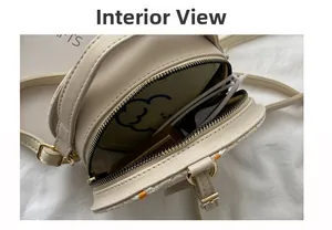Vue intérieure d'un sac bandoulière rond beige montrant l'espace pour téléphone et maquillage