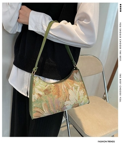 Detailed view of women's green floral jacquard underarm bag being worn over the shoulder