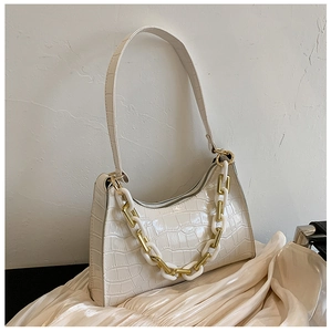 Detail of white crocodile pattern shoulder bag with distinctive thick chain and zipper
