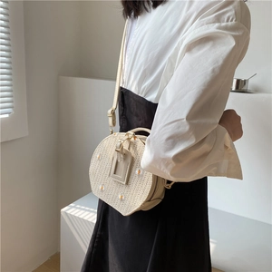 Sac bandoulière rond en paille tissée avec broderie marguerite et lanière en cuir souple