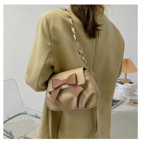 Détail du sac beige plissé avec nœud marron et bandoulière tressée pour femmes