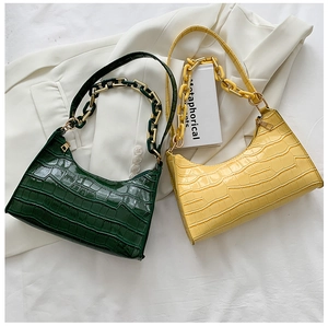 Detail of dark green and yellow crocodile pattern baguette bags with chunky acrylic chains