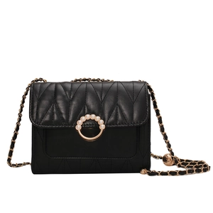 Sac bandoulière matelassé noir avec boucle de perles et bandoulière chaîne dorée sur fond blanc