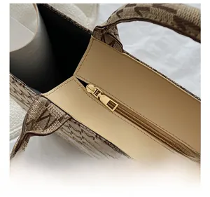 Détail de la fermeture éclair en métal doré et du sac cabas en toile à motifs M