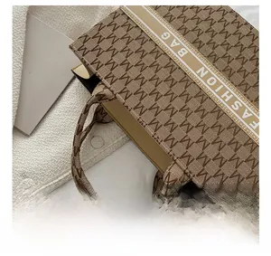 Détail du sac cabas rétro en toile avec motif jacquard M et poignées en sangle tressée