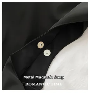 Détail du fermoir magnétique sur un sac à bandoulière en tissu Oxford noir de qualité