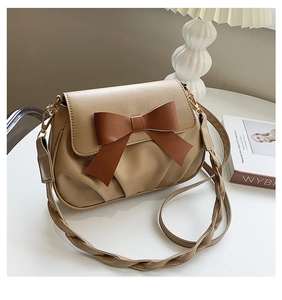 Détail du sac bandoulière en cuir kaki avec nœud marron et bandoulière tressée