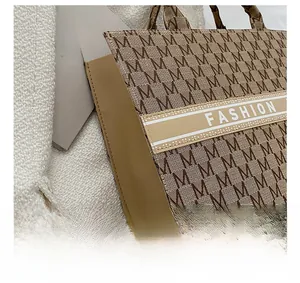 Détail des coutures et du motif M tissé sur ce sac cabas élégant en toile marron