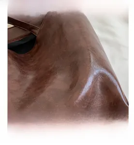 Détail macro du cabas en similicuir marron avec texture vieillie et fini ciré