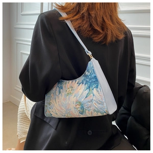 Detail of vintage floral jacquard underarm bag with blue leather strap and gold hardware