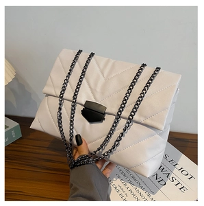 Detail of white quilted chain bag with V-shaped embossing on textured leather