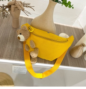 Detail of yellow canvas waist bag featuring a 3D plush teddy bear and adjustable strap