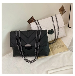 Close-up of quilted leather flap bags in black and white with metal chain straps