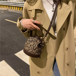 Vintage leopard print cylinder bag with leather trim and adjustable shoulder strap