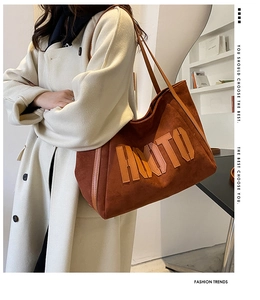 Close-up of suede tote bag with HMOTO letter embroidery and leather handle details