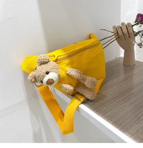 Detail of yellow canvas waist bag featuring a cute 3D plush bear and adjustable strap