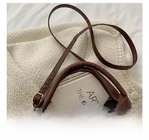 Close-up of brown quilted faux leather handbag with comfortable handle and gold hardware