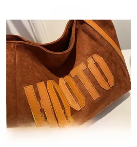 Close-up of deep brown suede tote bag with HOOTO letter patch and refined stitching detail