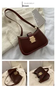 Detail of vintage brown leather handbag with a prominent square gold metal buckle