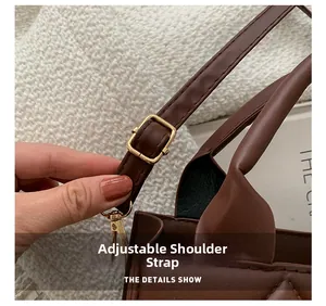 Close-up of brown quilted bag with adjustable strap and golden metal hardware