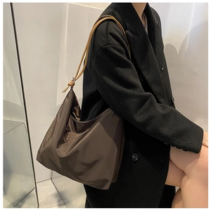 Détail de la texture douce du tissu Oxford et profil latéral du sac hobo marron foncé