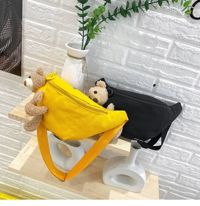 Detail view of canvas waist bags featuring 3D plush teddy bear and adjustable straps