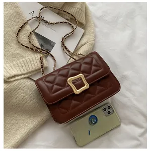 Quilted dark brown crossbody bag shown next to a smartphone for size scale reference
