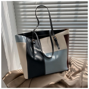 Detail of multi-color PU leather tote bag with golden metal buckles and fine stitching