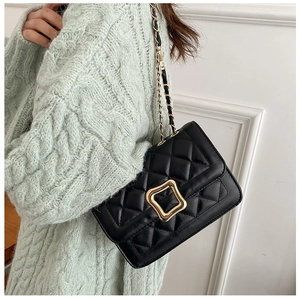 Detail of black quilted leather shoulder bag with gold metal buckle and chain strap
