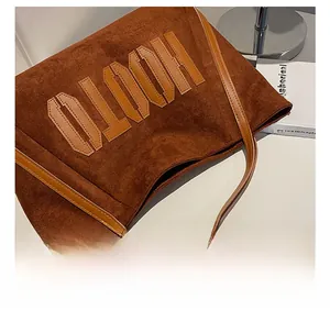 Detail view of the brown suede tote bag showing soft texture and OLOH letter patchwork