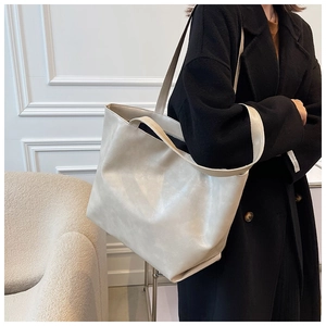 Détail d'un grand cabas crème avec texture en cuir fin et large bandoulière souple