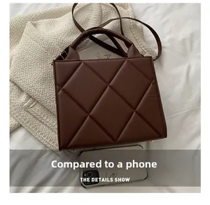 Top view of dark brown quilted mini square bag with leather texture on white fabric