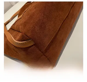 Detailed view of meticulous stitching on brown faux suede tote bag base