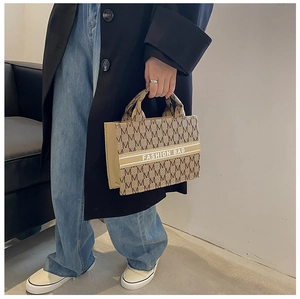 Détail d'un cabas en toile avec imprimé M et texte Fashion Bag porté par un mannequin