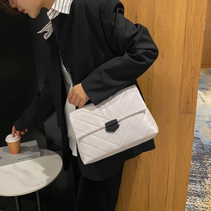 Chic white quilted shoulder bag with V-shaped stitching and black trapezoidal metal buckle