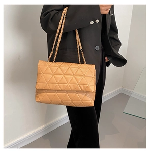 Détail du sac cabas matelassé marron clair avec coutures triangle et chaîne dorée