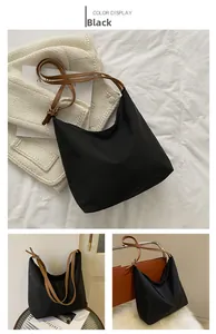 Détail du sac hobo en tissu Oxford noir avec bandoulière caramel et boucle en métal