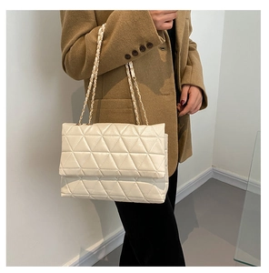 Détail du sac bandoulière crème en similicuir avec matelassage triangulaire et chaîne